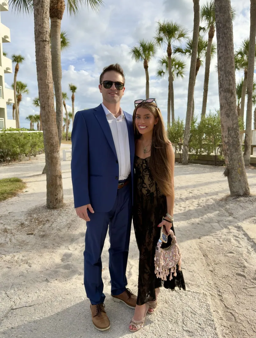 Frankie and Maddie dressed up on a palm-lined path